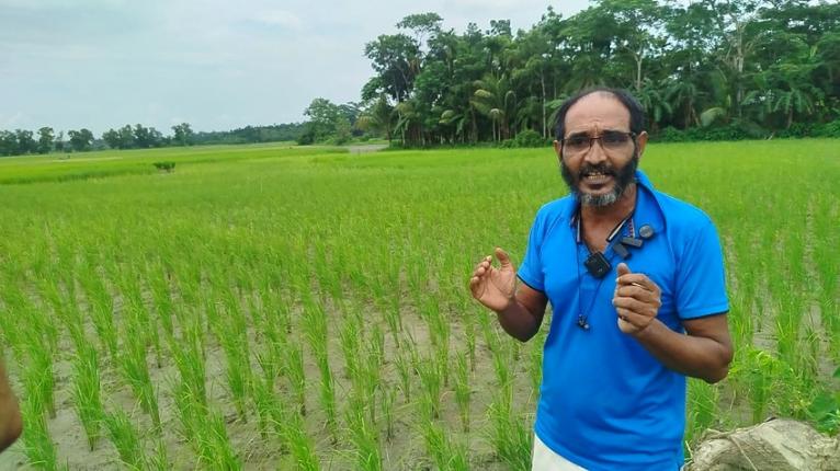 ছবিতে মামলার বাদী আল আমিন, পেছনে বিরোধপূর্ণ জমি।